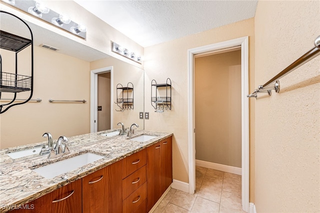 bathroom with vanity, tile patterned floors, and a textured ceiling