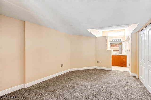 2260 First St Unit 207, Fort Myers, FL 33901 - unfurnished bedroom featuring light carpet, baseboards, and ensuite bath