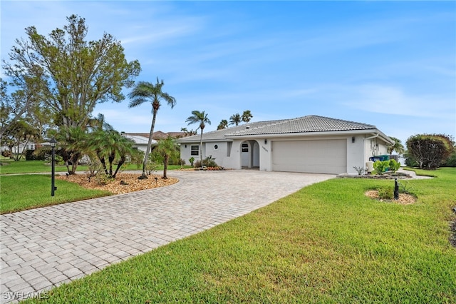 ranch-style house with a garage, decorative driveway, a front lawn, and stucco siding