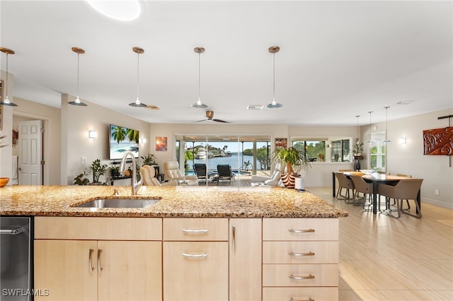 kitchen with pendant lighting, sink, ceiling fan, light stone countertops, and light brown cabinetry