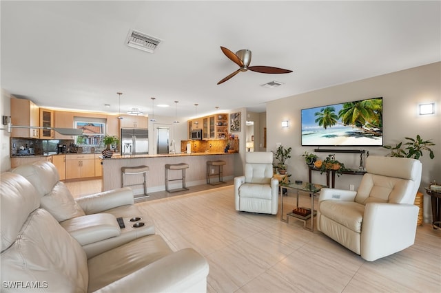 living area featuring a ceiling fan and visible vents