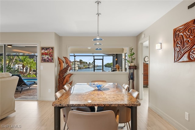 tiled dining room with a water view