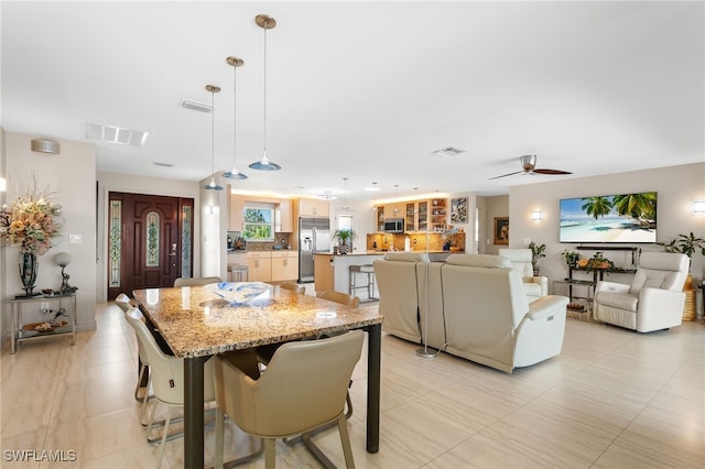 dining space with ceiling fan and visible vents