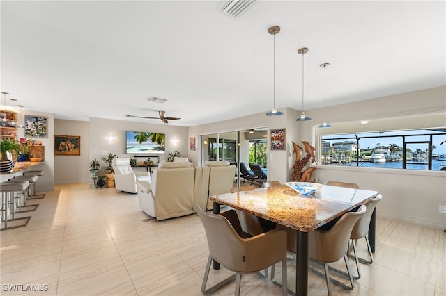 dining room featuring a ceiling fan, visible vents, and baseboards