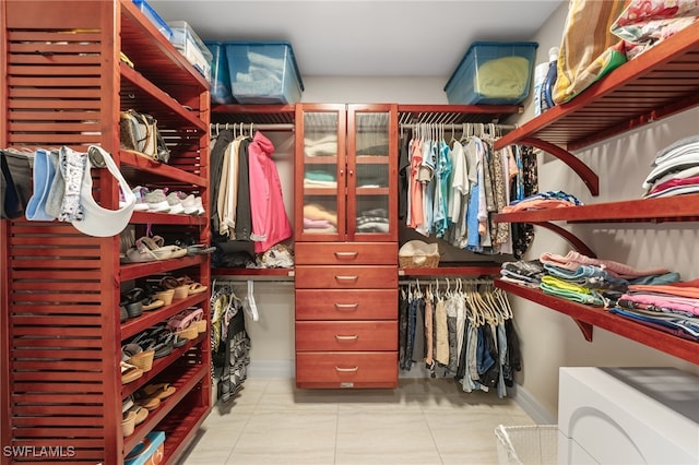 walk in closet with light tile patterned floors