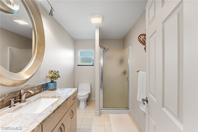 bathroom with tile patterned floors, vanity, toilet, and walk in shower