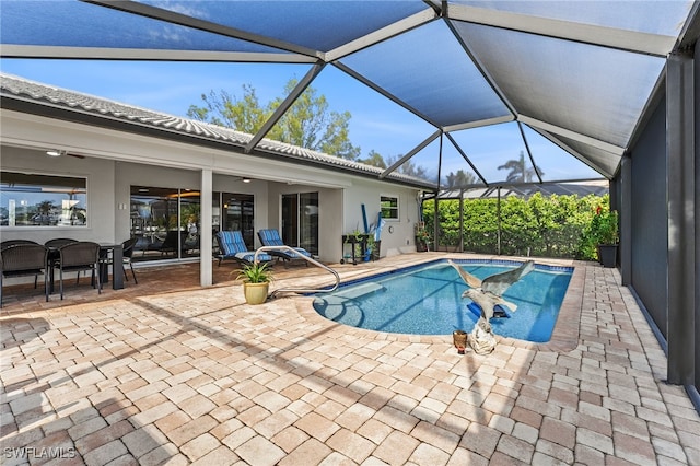 view of pool with ceiling fan, a patio area, and glass enclosure