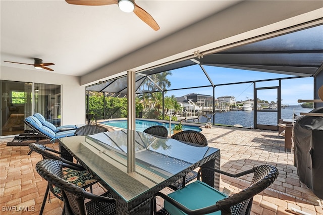 view of patio / terrace featuring a lanai and a water view