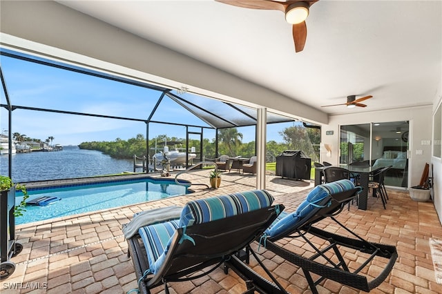 outdoor pool with a water view, a lanai, a ceiling fan, and a patio