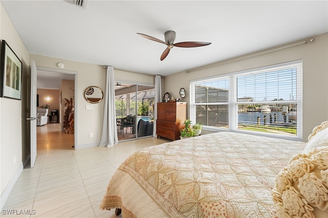 bedroom with multiple windows, access to outside, ceiling fan, and a water view