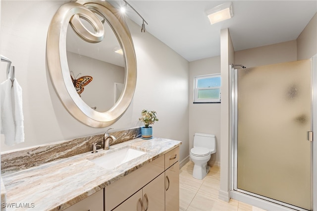 bathroom featuring toilet, vanity, tile patterned floors, and a shower with door