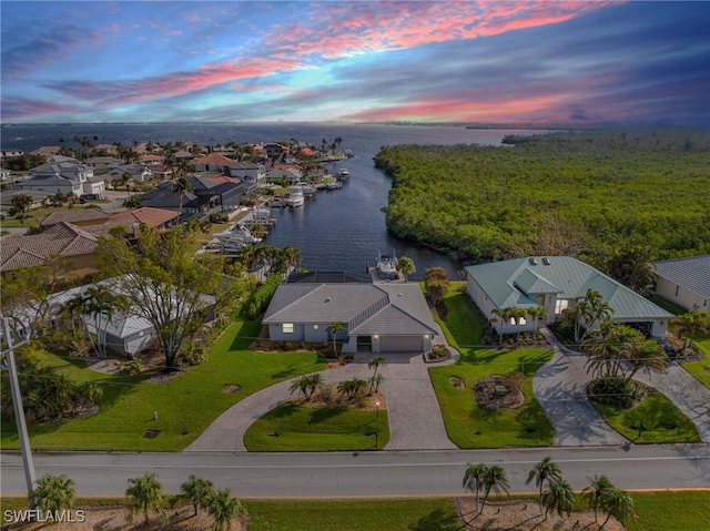 aerial view at dusk featuring a water view