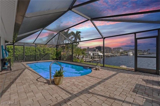 pool featuring a dock, a lanai, a patio area, and a water view