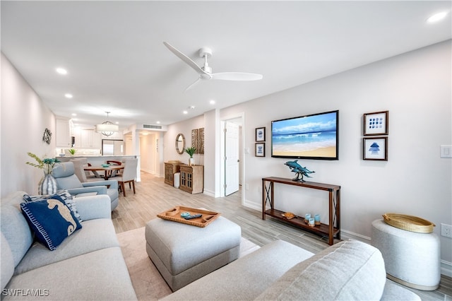 living room with ceiling fan and light hardwood / wood-style floors