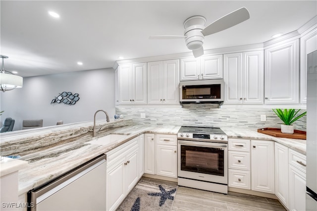 kitchen with stainless steel appliances, ceiling fan, sink, white cabinets, and light hardwood / wood-style floors