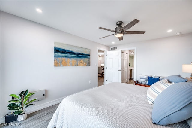 bedroom featuring connected bathroom, ceiling fan, and hardwood / wood-style floors