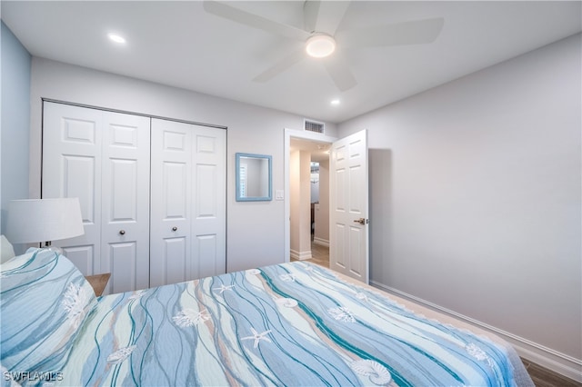 bedroom featuring hardwood / wood-style floors, a closet, and ceiling fan