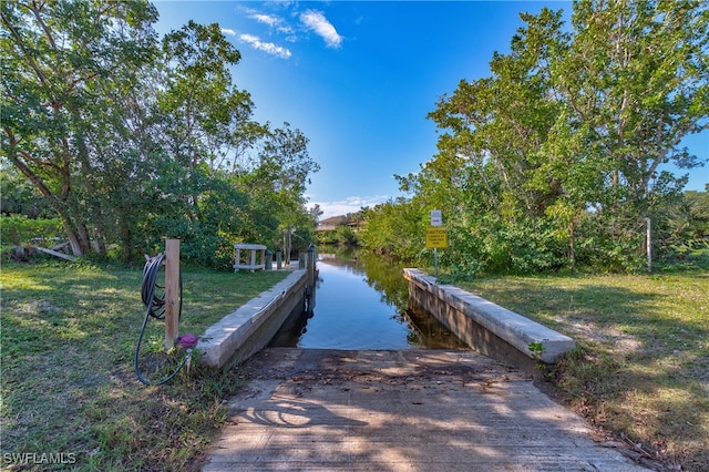 view of dock featuring a water view and a lawn