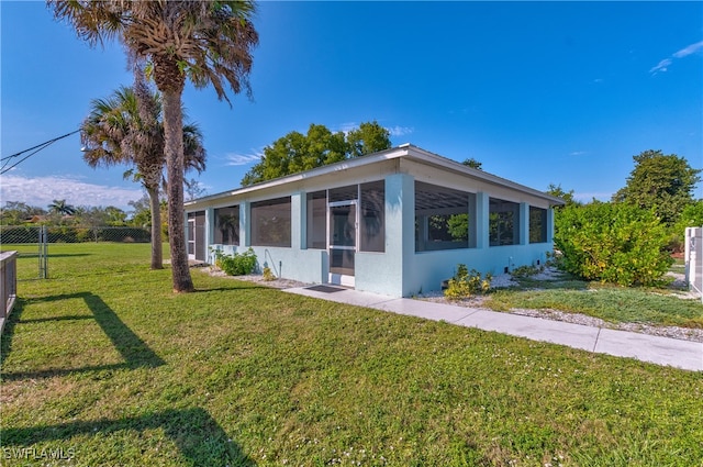 view of front facade featuring a front lawn and a sunroom