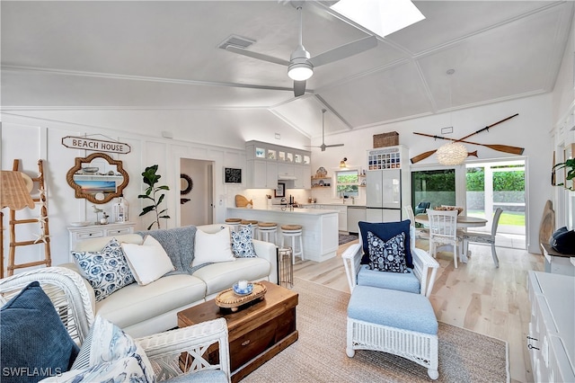 living room featuring ceiling fan, vaulted ceiling, and light hardwood / wood-style floors