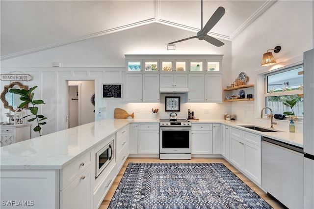 kitchen featuring sink, appliances with stainless steel finishes, white cabinets, and vaulted ceiling