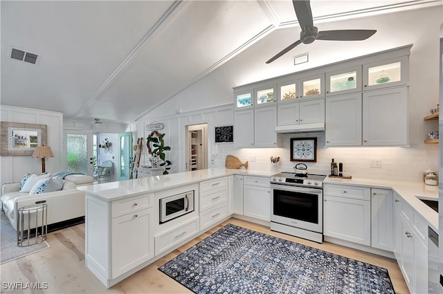 kitchen featuring lofted ceiling, white cabinets, kitchen peninsula, and stainless steel appliances