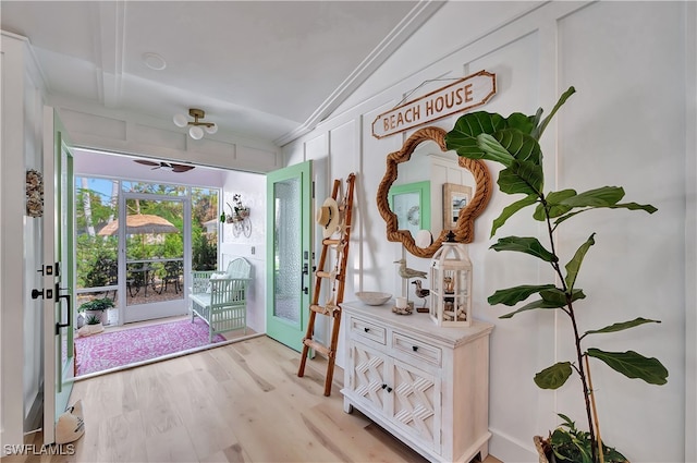 doorway to outside featuring ornamental molding, lofted ceiling, light wood-type flooring, and ceiling fan