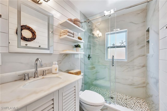 bathroom featuring vanity, toilet, and a shower with shower door