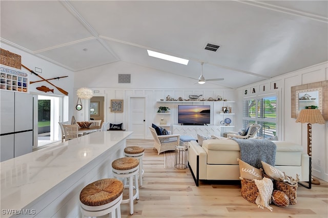 living room with ceiling fan, lofted ceiling, and light wood-type flooring