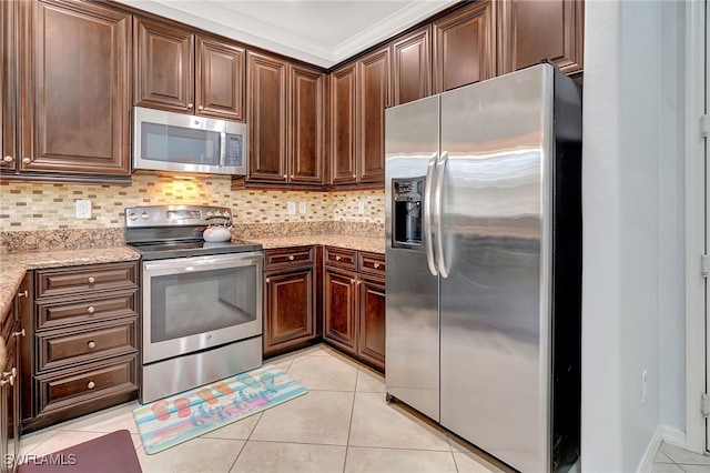 kitchen with light stone countertops, light tile patterned floors, decorative backsplash, and appliances with stainless steel finishes