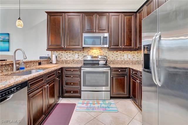 kitchen with pendant lighting, appliances with stainless steel finishes, tasteful backsplash, sink, and crown molding