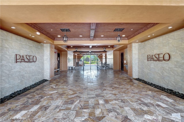 interior space featuring tile walls, a tray ceiling, and wood ceiling