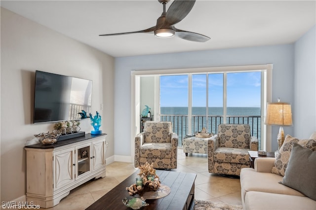 tiled living room featuring a water view and ceiling fan