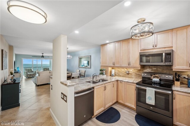 kitchen with decorative backsplash, appliances with stainless steel finishes, light brown cabinets, and sink