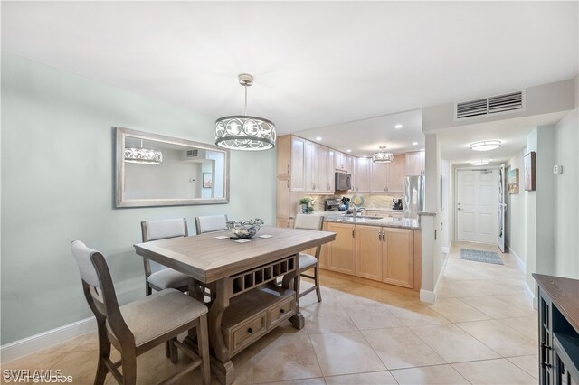 tiled dining area with a notable chandelier