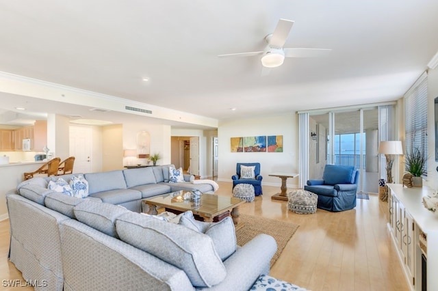 living room with crown molding, light wood-type flooring, and ceiling fan