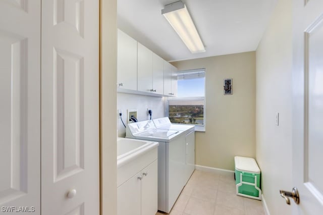 laundry room with cabinets, washer and dryer, and light tile patterned floors