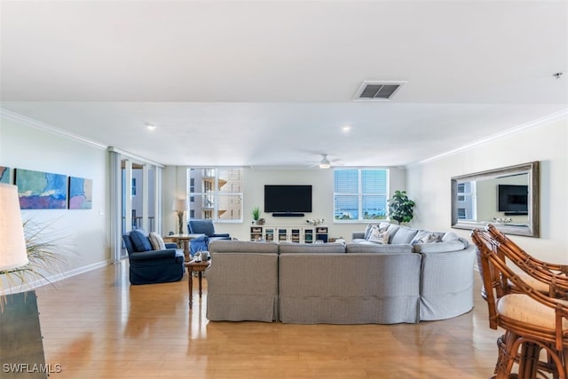 living room with crown molding, light wood-type flooring, and ceiling fan