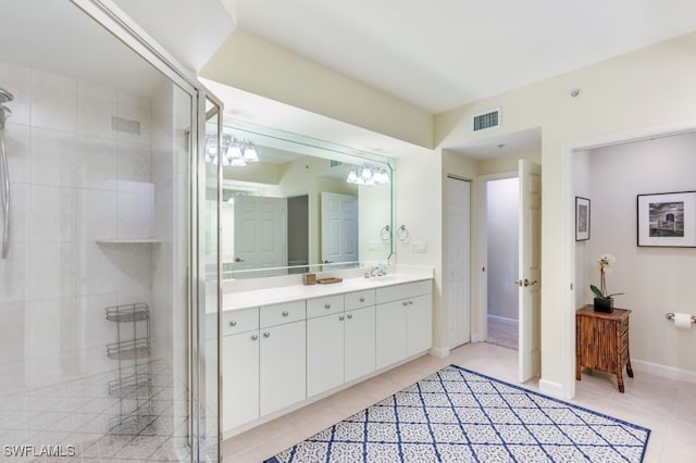 bathroom featuring vanity, a shower with shower door, and tile patterned floors