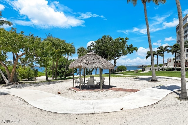 view of jungle gym featuring a gazebo, a lawn, and a water view