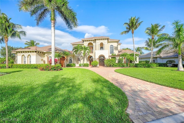 mediterranean / spanish home with a front lawn