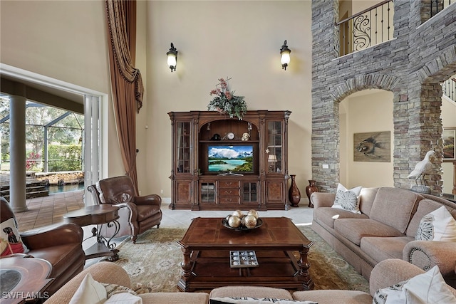 living room with a high ceiling and light tile patterned floors