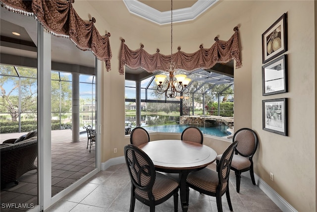 dining area featuring ornamental molding, a notable chandelier, a tray ceiling, and light tile patterned floors