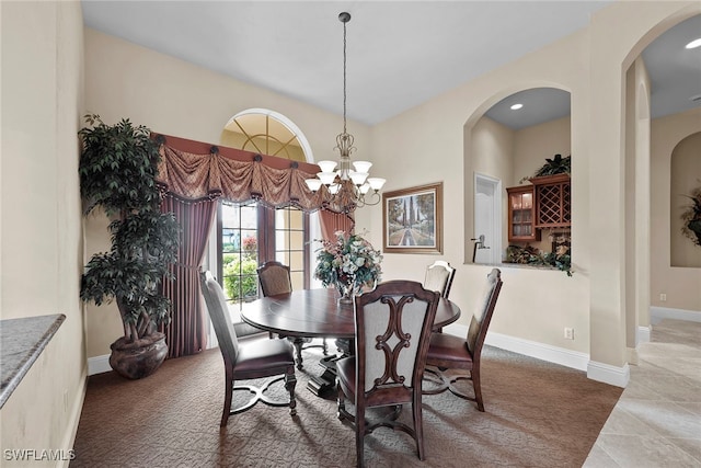 carpeted dining room featuring a chandelier