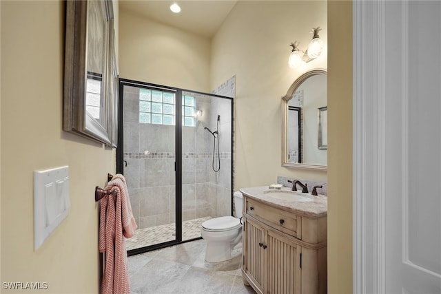 bathroom with vanity, tiled shower, toilet, and tile patterned flooring