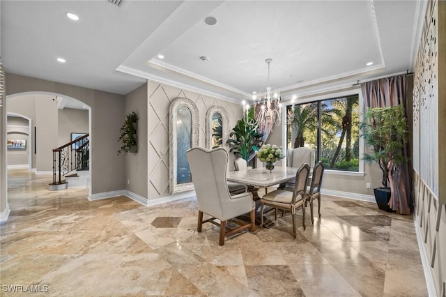 dining area with a tray ceiling and a chandelier