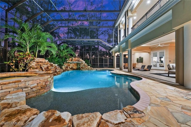 view of swimming pool with glass enclosure, ceiling fan, french doors, pool water feature, and a patio