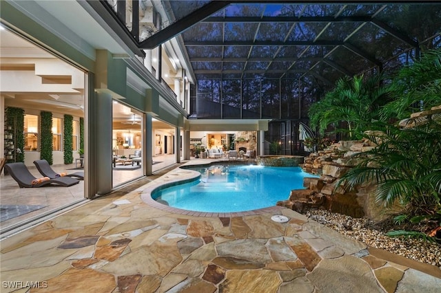 view of pool with a lanai, a patio area, and pool water feature