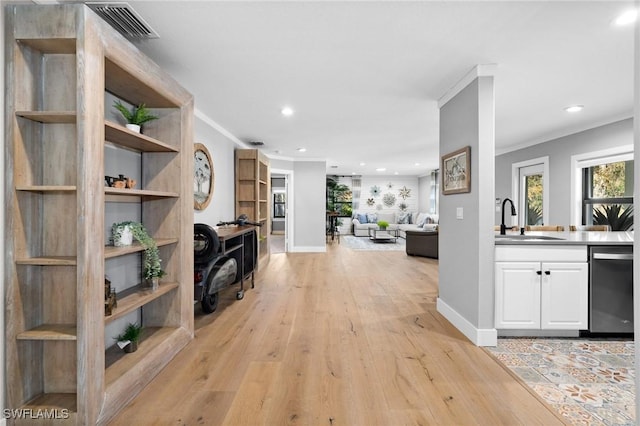 corridor featuring light hardwood / wood-style floors, crown molding, and sink