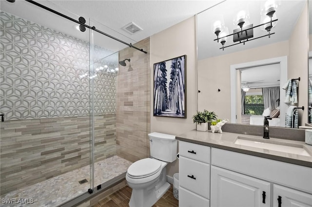 bathroom featuring a textured ceiling, vanity, an enclosed shower, and toilet